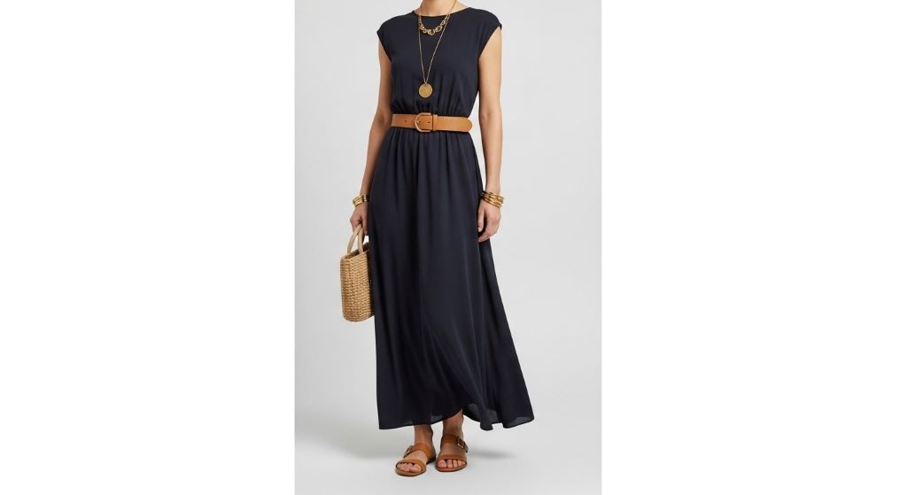 Dark navy maxi dress styled with tan belt, gold jewelry, and flat sandals demonstrating elegant daytime outfit combination